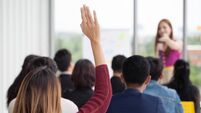 young businesswoman raising hand  to question from Speaker in Seminar. Group Meeting . Conference  Concept . Rear back view
