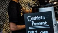 London- June 2023: A person makes a coffee at a London coffee shop with a sign saying 'Only Card' and 'Cashless payment'-