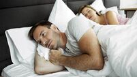 Man in bed can not sleep because his wife is snoring