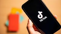 Rome, Italy, 24 January 2021. Overhead shot of a human hand holding a smartphone with the TikTok logo.