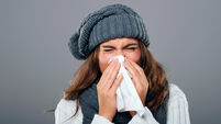 Woman in winter clothes sneezing Debica, Poland