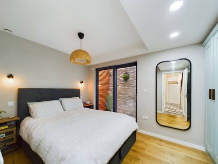 Main bedroom with French doors to small patio