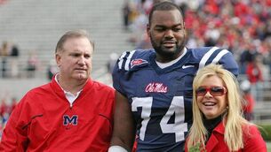 <p>Michael Oher with the Tuohys</p>
