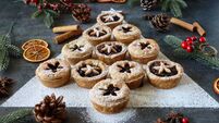 Close-up image mince pies laid out like Christmas tree surrounded by decorations, festive Christmas dessert, cinnamon stick bund
